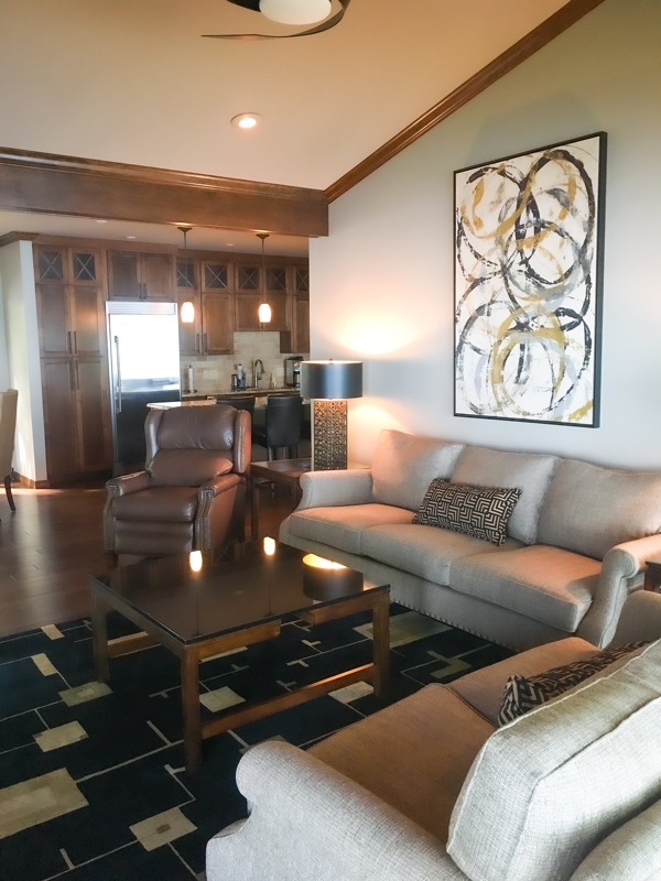 swirl artwork with tan sofa living room design 