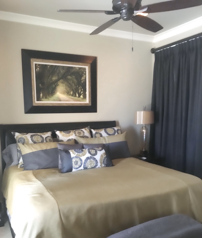 guest bedroom with yellow and grey bedding and grey window curtains