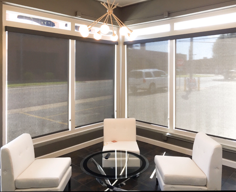 black graber solar shades for office window in lobby with white chairs
