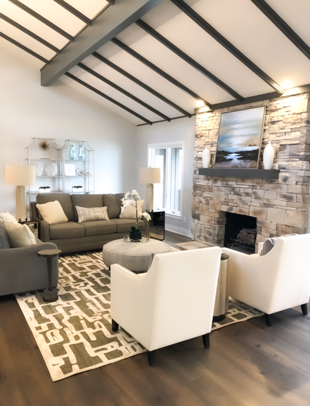 stone fireplace and two white chairs with grey sofa living room 