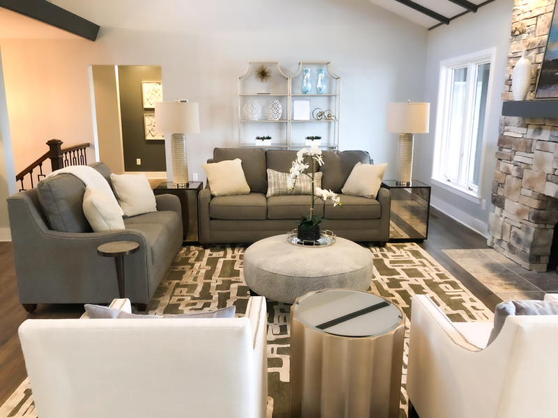 living room with grey sofas and white chairs 