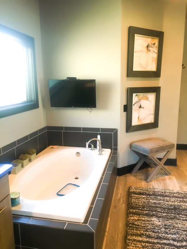 master bath with two pictures and tan bench 