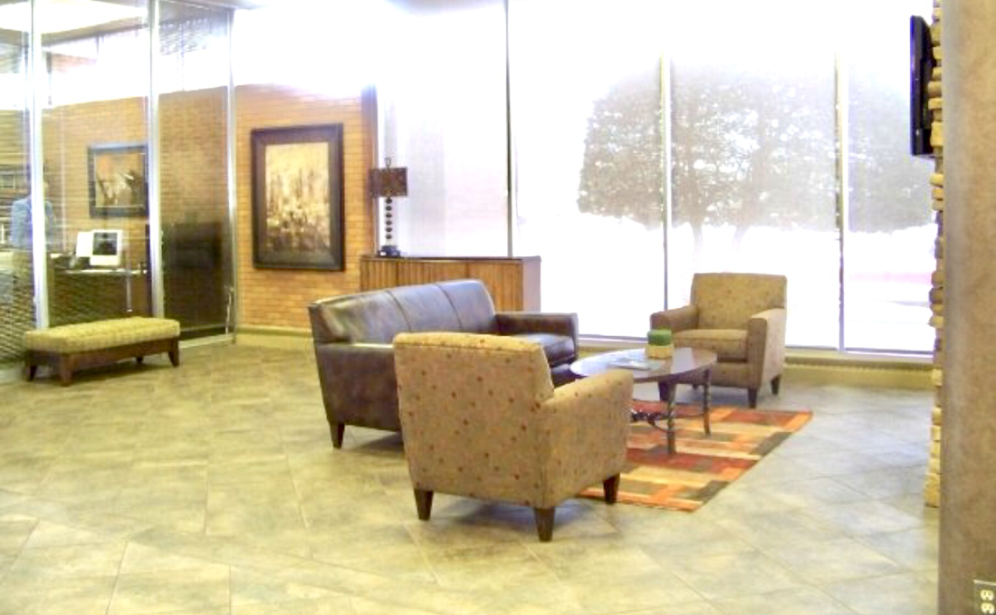 office waiting area with leather sofa two chairs  and credenza